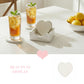 Iced tea on heart coasters and a white wooden holder on a white table, with a pink heart and "Beauty in Display" text.