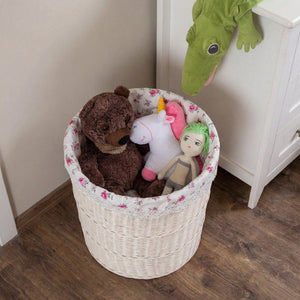 Large Cottage Wicker Hamper beside a white cabinet storing stuffed toys on a wooden floor
