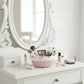 Makeup vanity with decorative mirror Cottage Round Wicker Basket and various makeup items on a white surface.