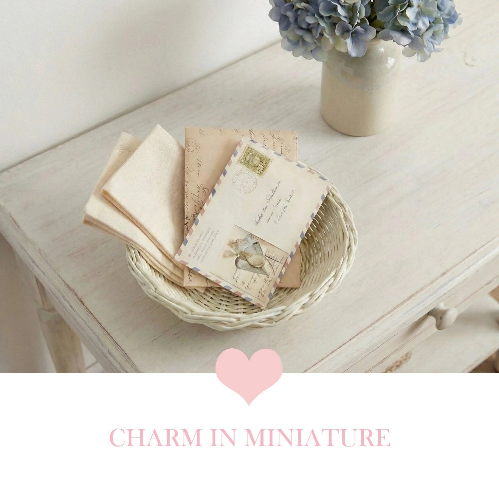 Mini Wicker Basket styled with vintage books and postcards on wooden table with floral background decor