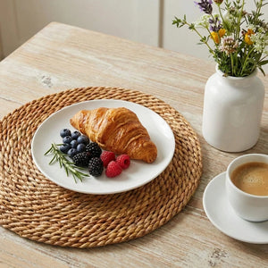 Breakfast setting with croissant, berries, and coffee on a wooden table.