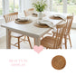 Natural halfa grass round placemats arranged on a white farmhouse dining table with four wooden chairs, featuring a central wildflower vase and linen napkins.