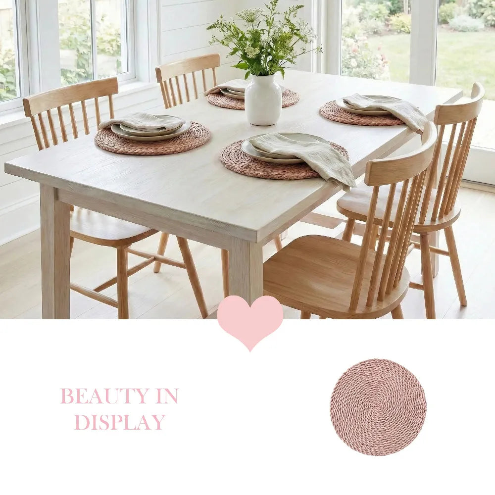 Dining table set with chairs, placemats, and a vase of flowers in a bright room.