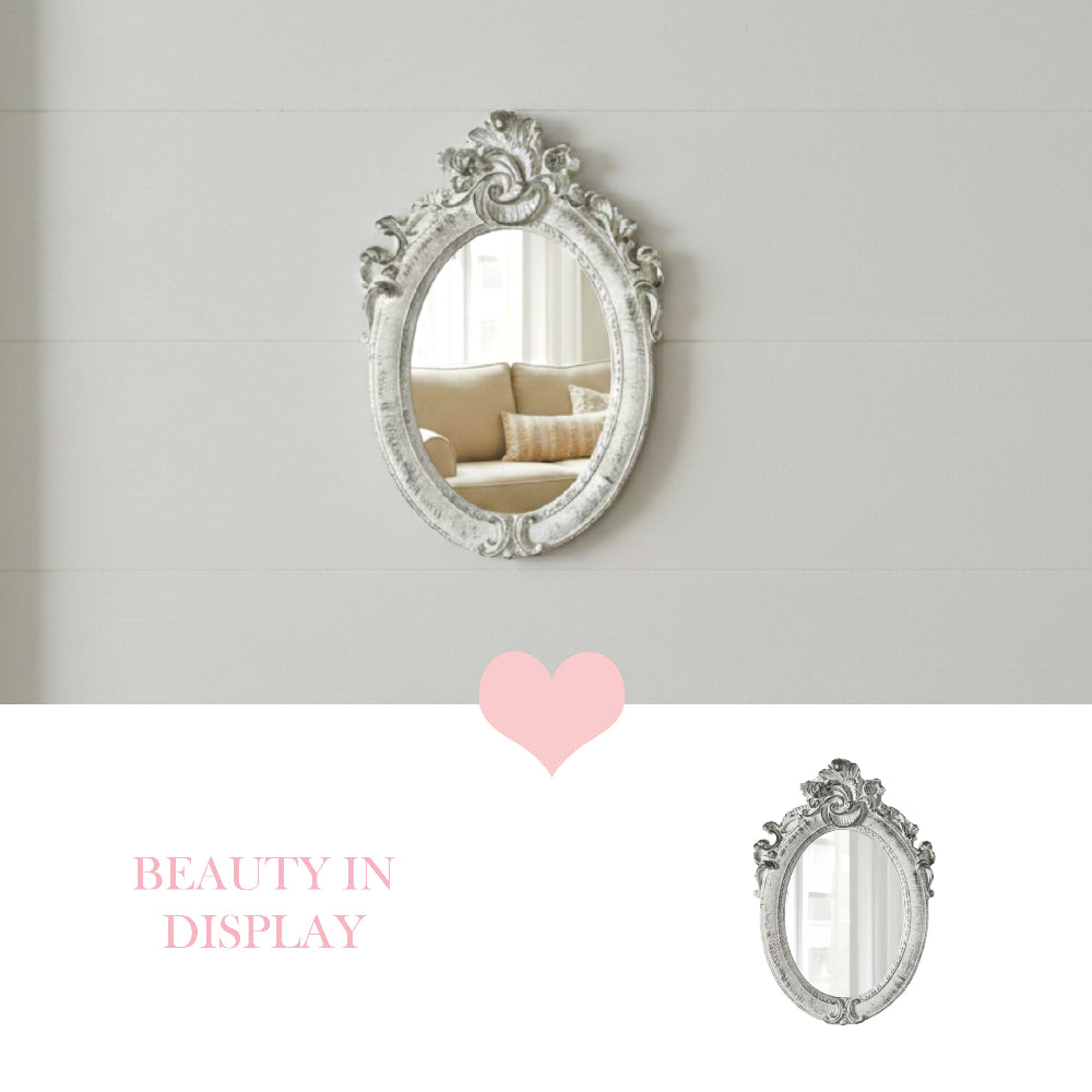 Ornate white oval mirror on a white shiplap wall reflecting a couch, with a pink heart and Beauty in Display text.