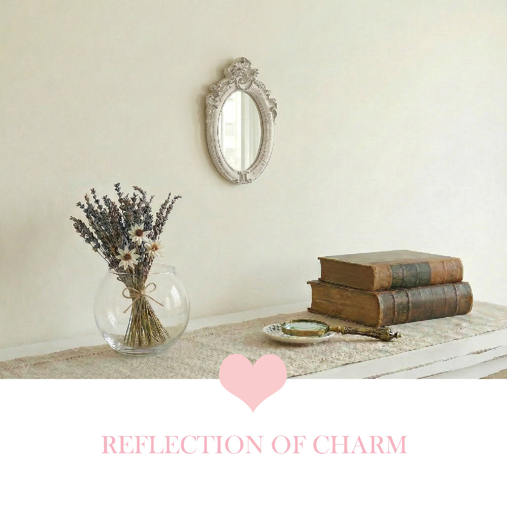 Ornate white oval mirror on a white wood vanity next to makeup brushes, lipstick, and a gold compact.