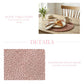 Rustic table setting with a woven placemat, mug, and bread on a white background.