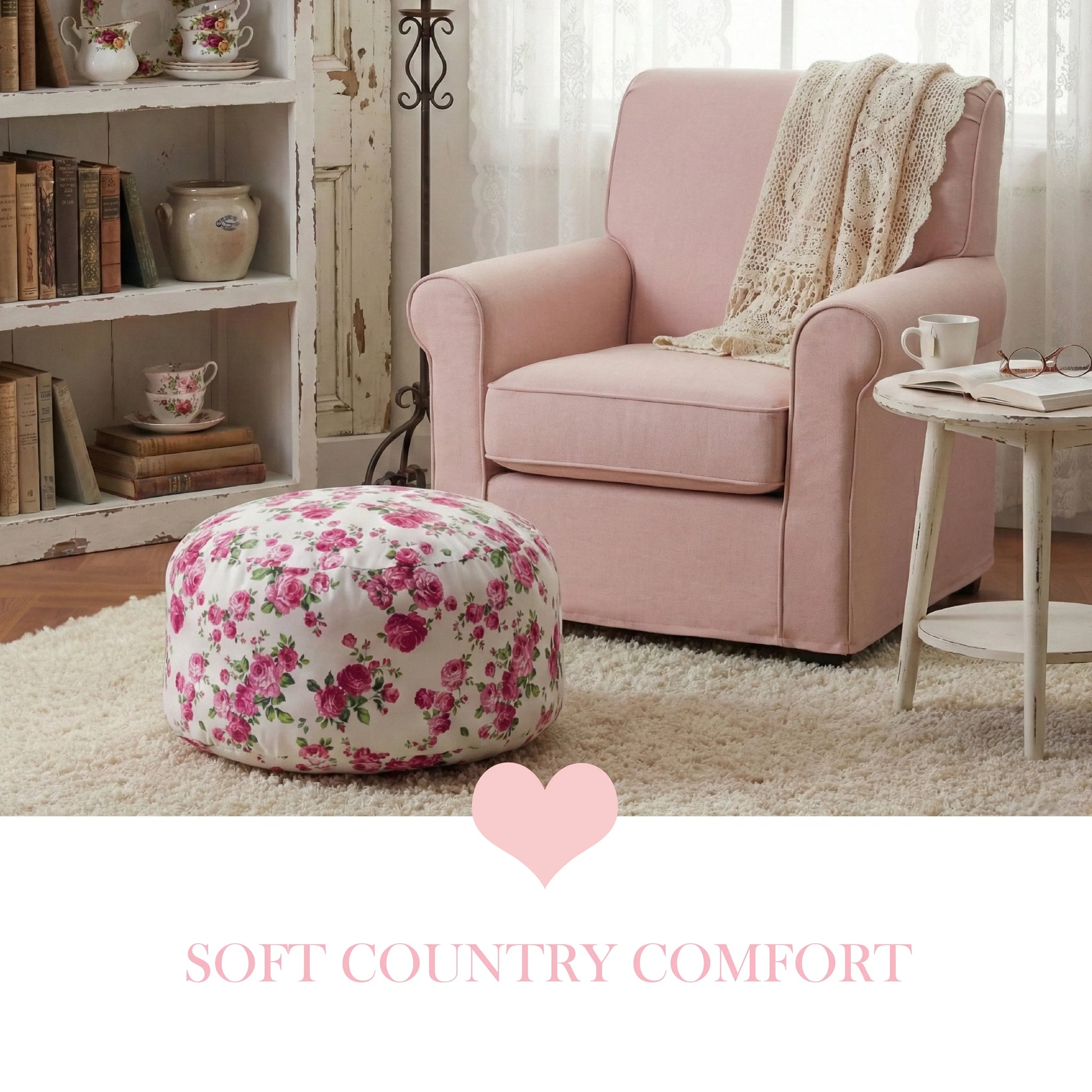 A pink rose fleur pouf on a cream shag rug next to a pale pink armchair with a lace throw, vintage bookshelf, and white side table.