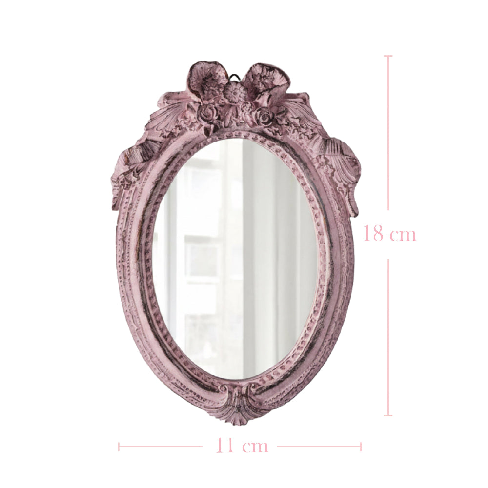 Small pink oval mirror with ornate floral carvings and dimensions indicating 18 cm height and 11 cm width.