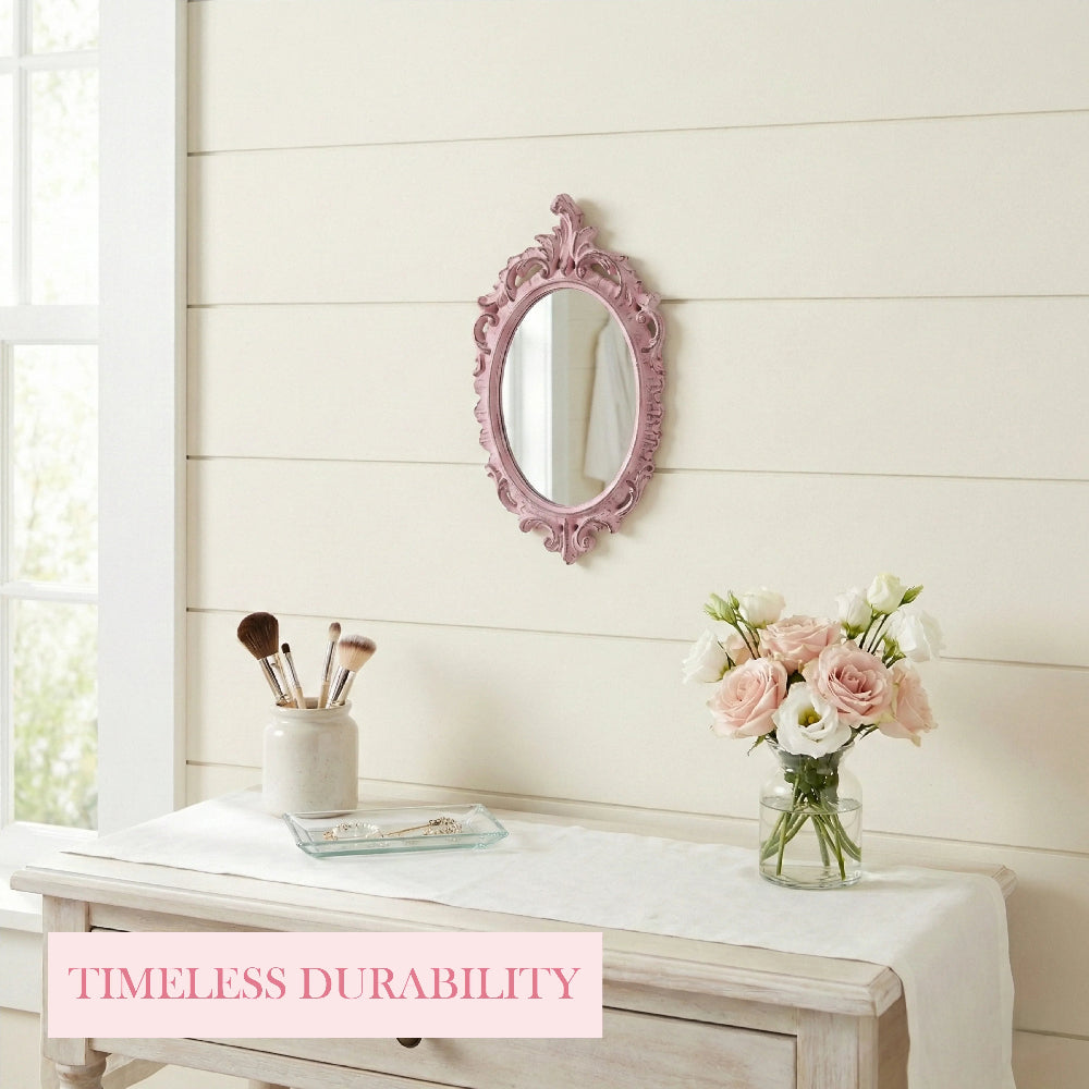Pink ornate oval mirror on a shiplap wall over a vanity with makeup brushes, a glass tray, and pink and white roses.