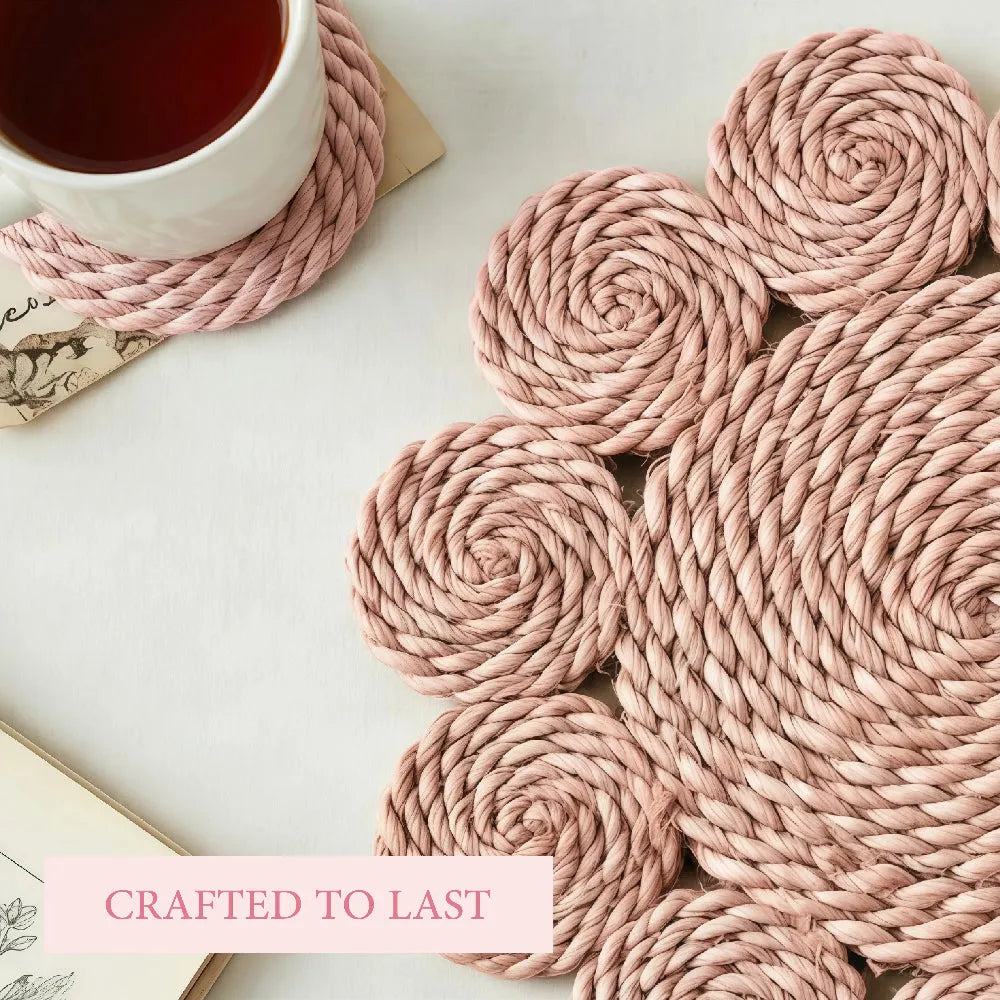 Pink woven coasters on a white surface with a cup of tea.