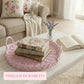 Pink woven tray with floral books on a coffee table in a cozy living room.