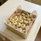 Box of cookies with pistachios on a white wooden table