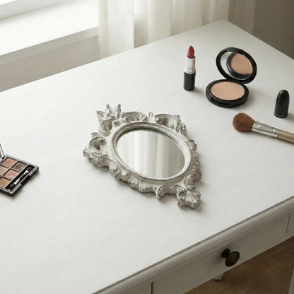 Pretty Shabby Wall Mirror Oval Chic shown with makeup items including lipstick, brushes on white surface