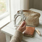 Pretty Shabby Wall Mirror Oval Chic held by person on wooden surface with notebook and pouch for home decor styling
