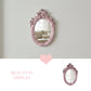 Pretty Shabby Wall Mirror – Oval Fleur with decorative pink frame and Beauty in Display text on light gray wall