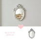 Pretty Shabby Wall Mirror – Oval Fleur with decorative frame displayed on a light gray wall beside product text