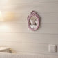 Pretty Shabby Wall Mirror – Oval Fleur mounted on a light wooden wall with a pink distressed frame