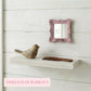 Pretty Shabby Wall Mirror – Square Chic above shelf with bird and comb against light wooden panel wall
