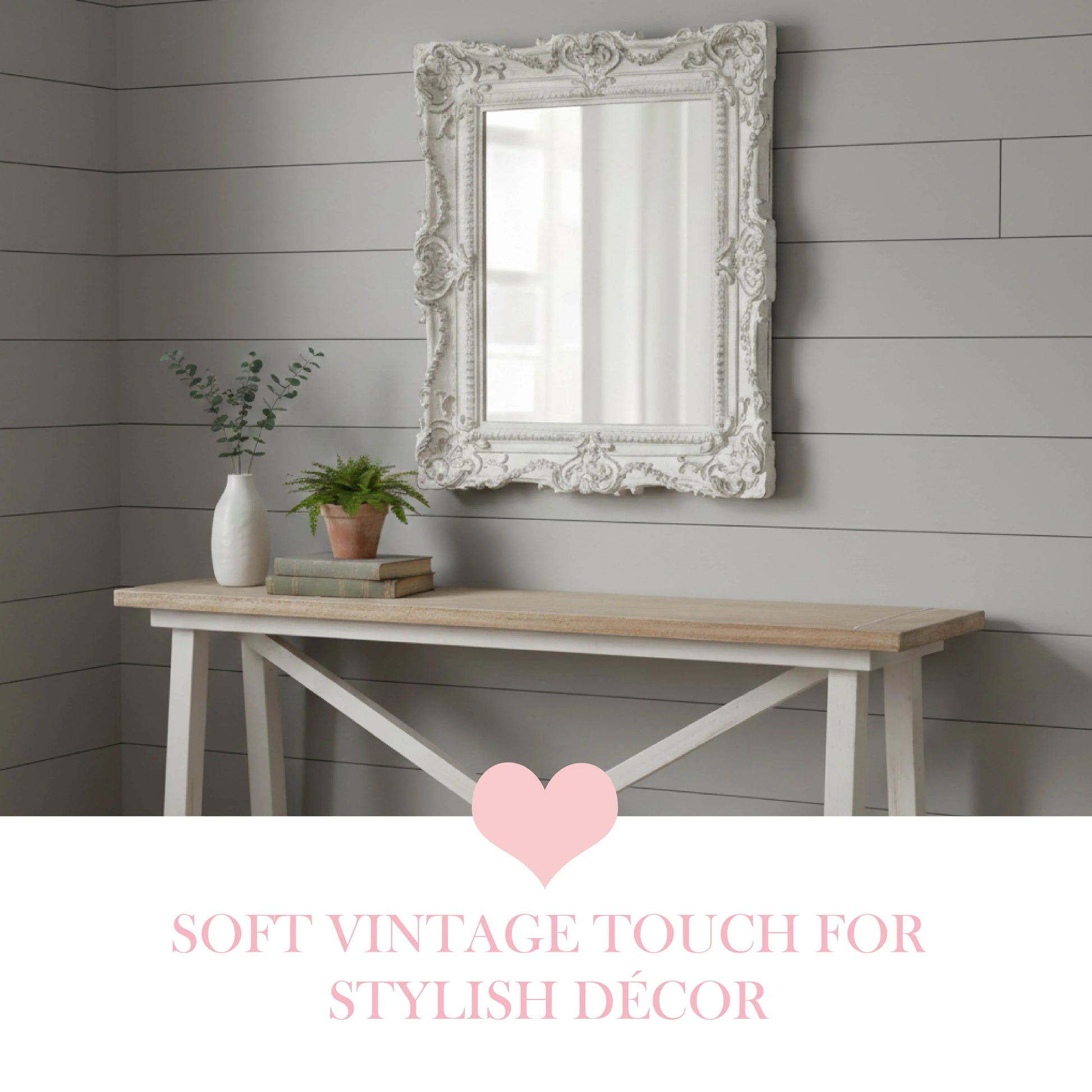 Decorative mirror on a wall above a wooden table with plants, against a gray wooden panel background.