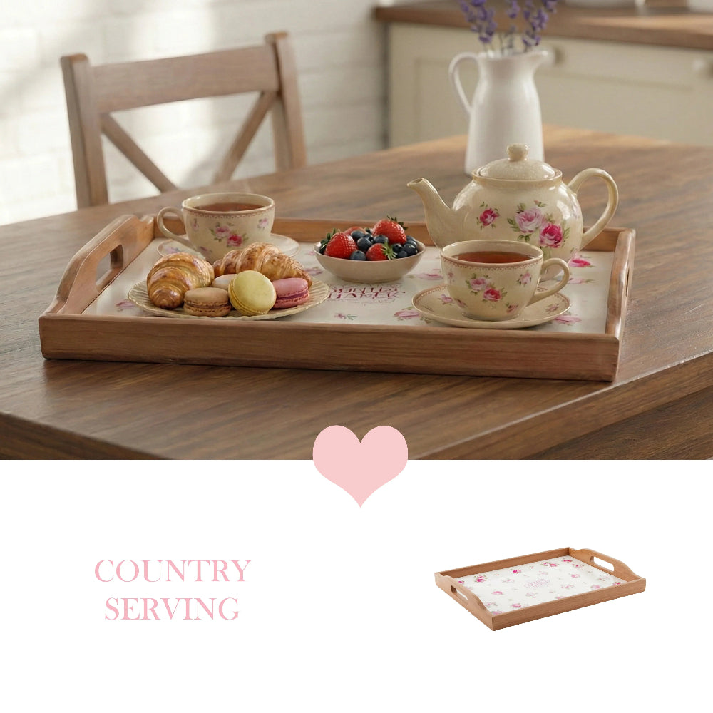 Wooden floral tray with a tea set, croissants, and macarons on a wooden table, featuring a pink heart and tray icon.
