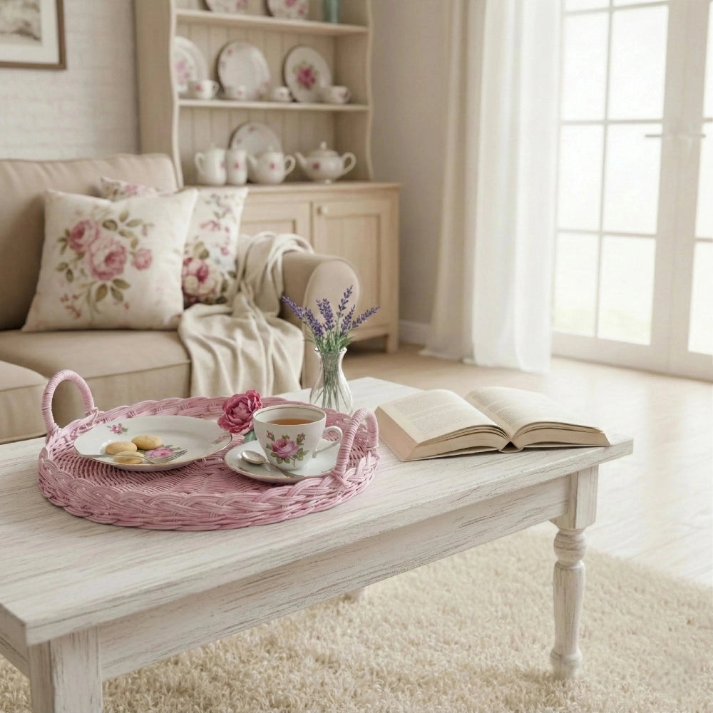Round pink wicker tray styled on coffee table with tea set and books for living room décor