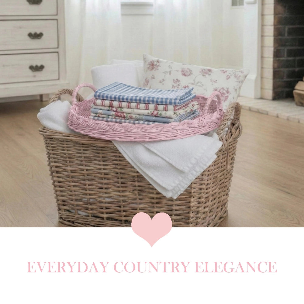 Round Wicker Tray with folded fabrics and pillow displayed on wooden floor in country style home décor setting