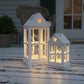 Rustic Wooden Heart Cut-Out Lantern with two illuminated white heart lanterns on wooden surface