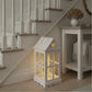 Decorative lantern with glowing interior lights placed under a staircase.