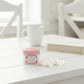 Scent of Love home fragrance soy wax melts jar on a bright white wooden table with matching chairs.