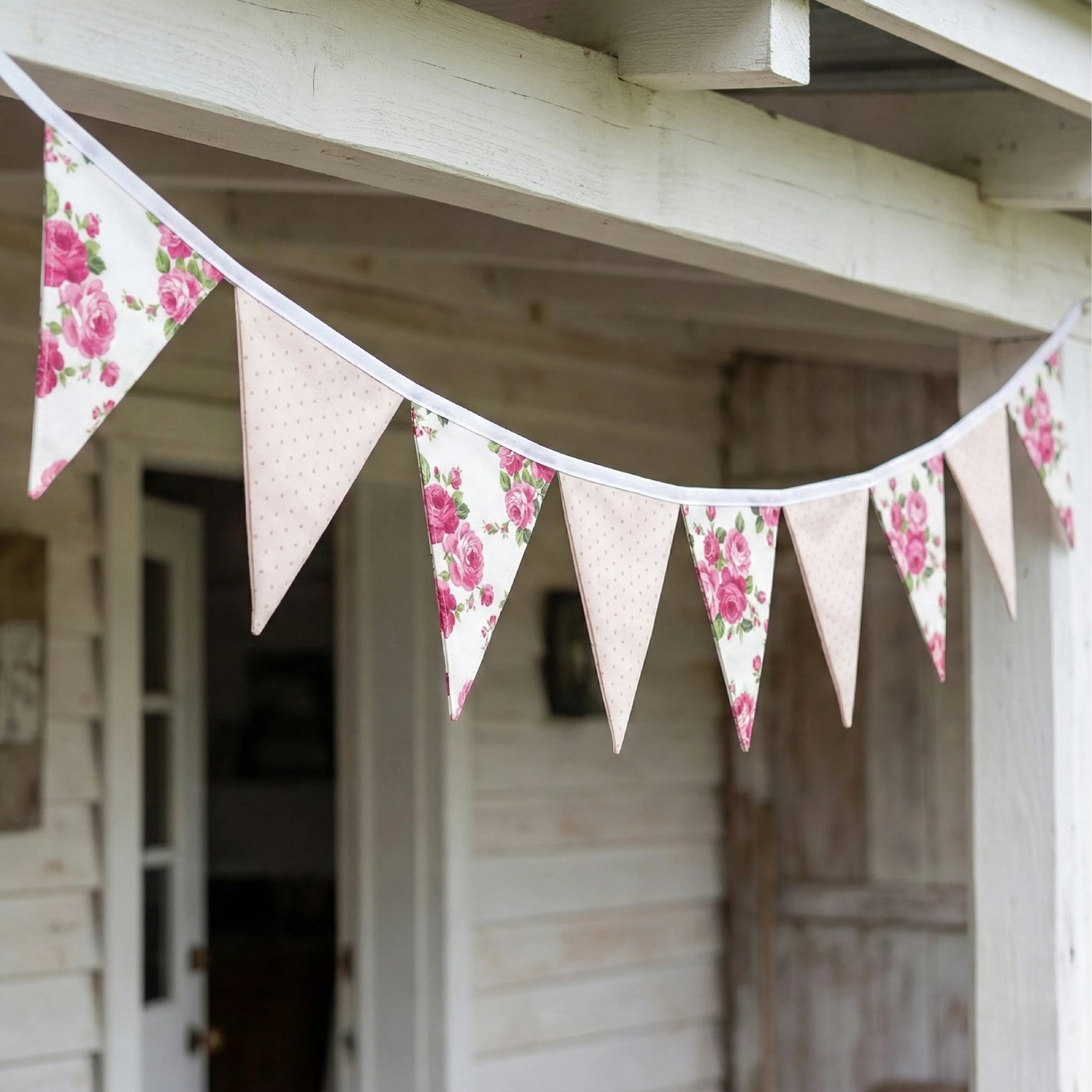 Shabby Chic Fleur & Polka Dot Pennant Banner Flag featuring pink rose floral and neutral polka dot triangle flags hanging across a rustic white wooden porch.
