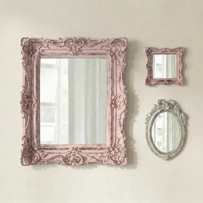 Pretty shabby mirrors collage with pink and gray frames on a light beige wall.