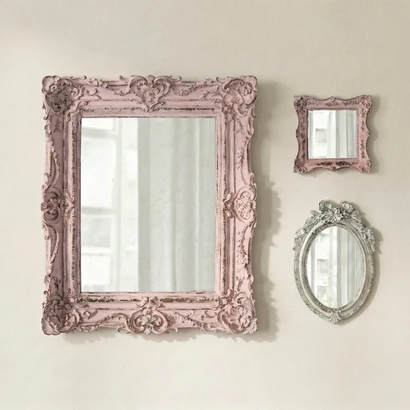 Pretty shabby mirrors collage with pink and gray frames on a light beige wall.