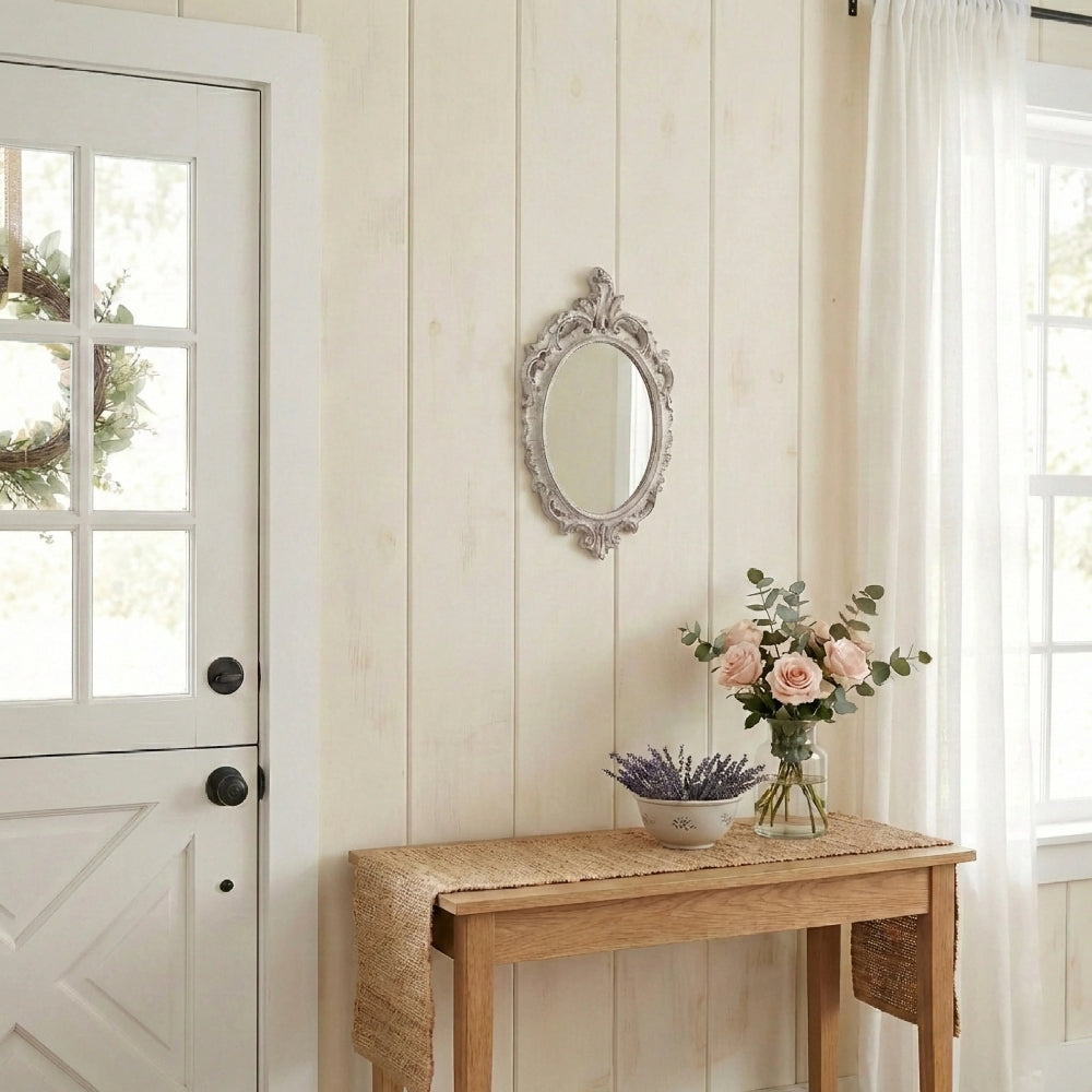 Small ornate mirror on shiplap wall over a console table with a jute runner, roses, lavender, and a white Dutch door.