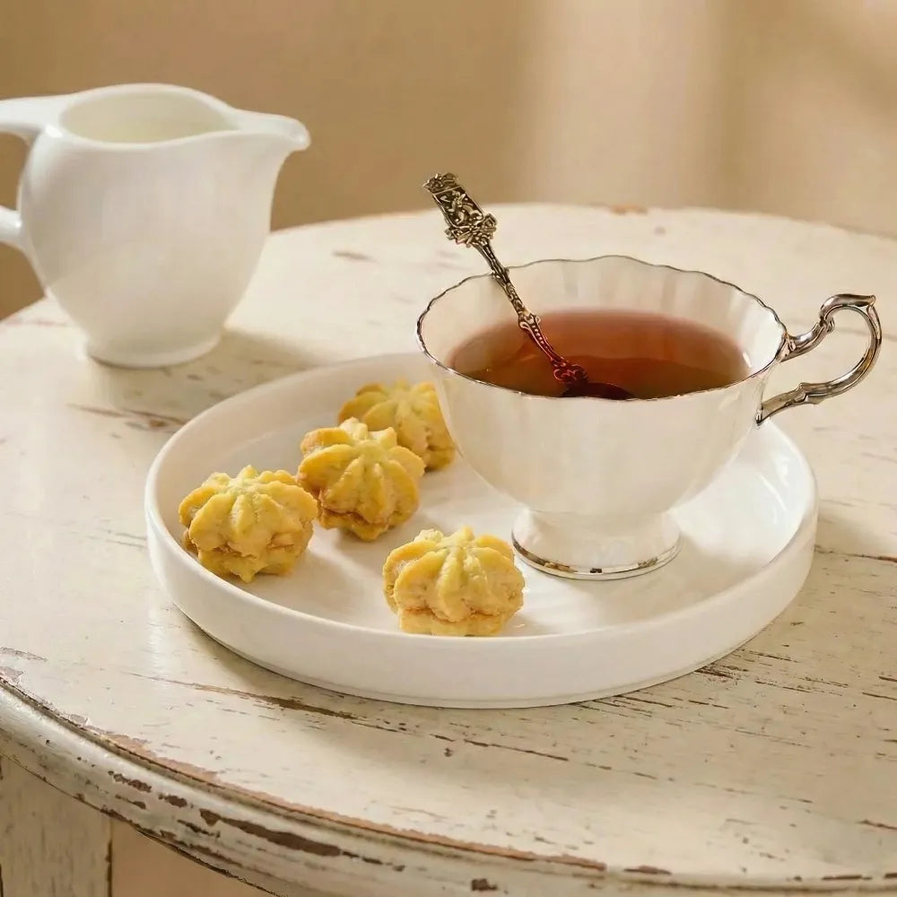 Tea cup with petit four cookies on a wooden table