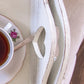 Teacup with saucer and spoon on a textured surface