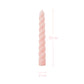 Pink twisted candle with measurements on a white background