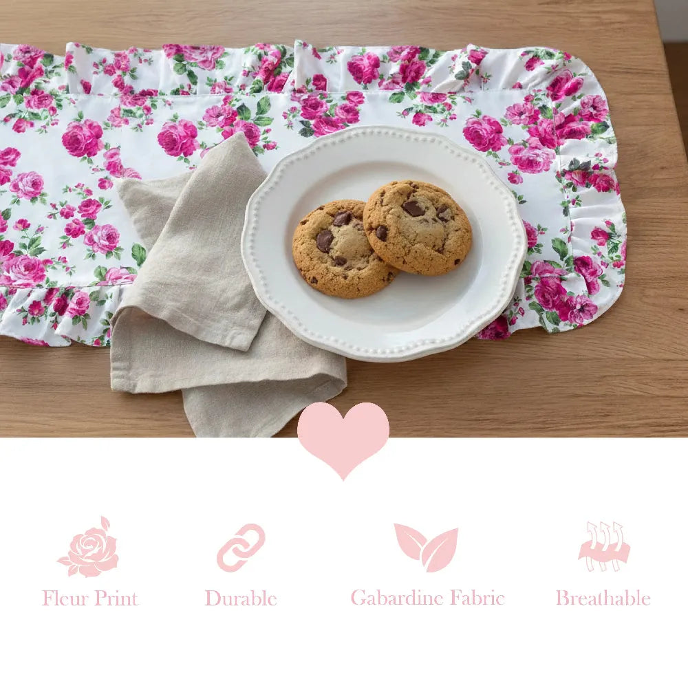 Floral table runner with cookies on a plate, placed on a wooden surface.