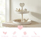 Two-tier white wooden tray with heart handle holding bird figurines, featuring four pink product feature icons below.