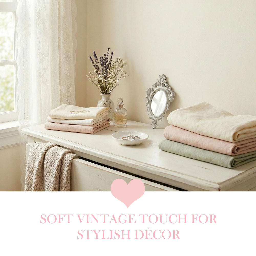 Folded linens, lavender in a vase, and an ornate oval mirror on a white dresser with "Soft Vintage Touch" text.