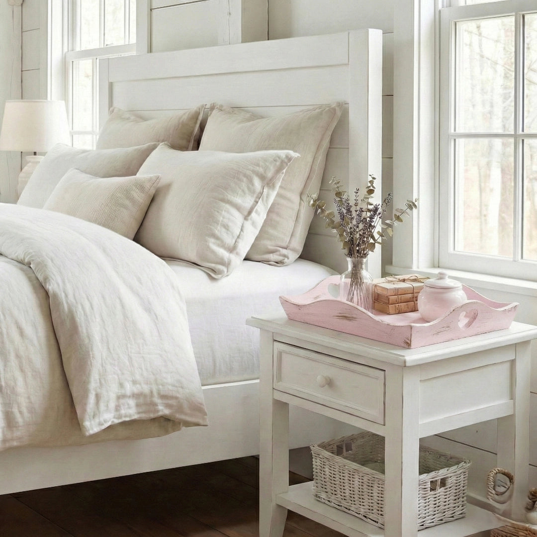 Neatly made bed with white bedding and pillows in a bright bedroom.