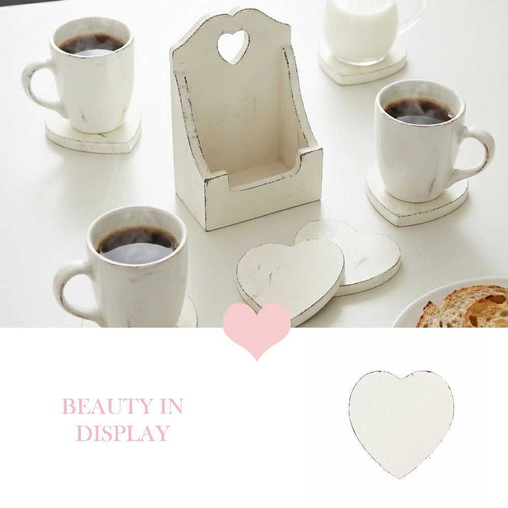 Three white mugs and a milk jar on heart coasters next to a tall wooden holder with pink text and a heart icon.