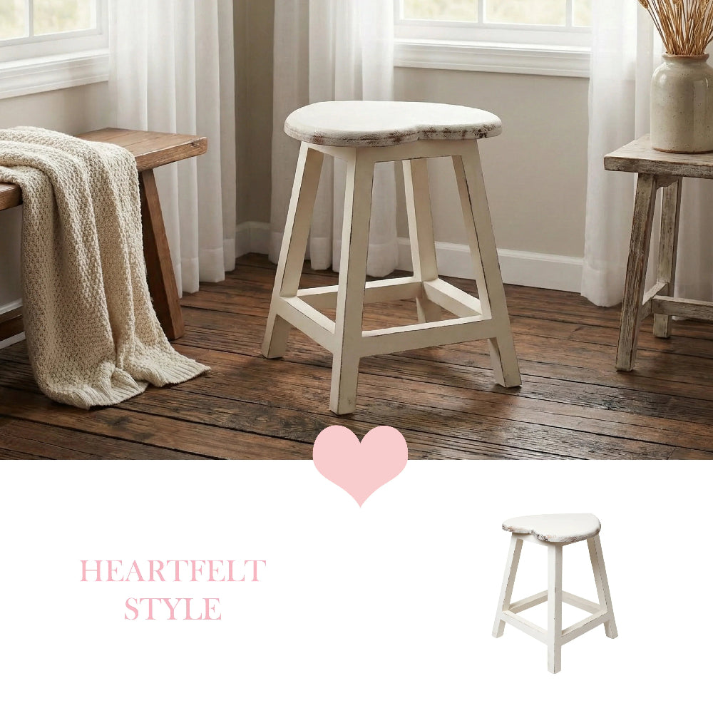 White heart-shaped stool on a wooden floor in a room with a bench, knit throw, and pink text overlay.