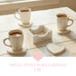 Three white mugs on heart coasters next to a wooden holder on a white table with a pink heart and text overlay.