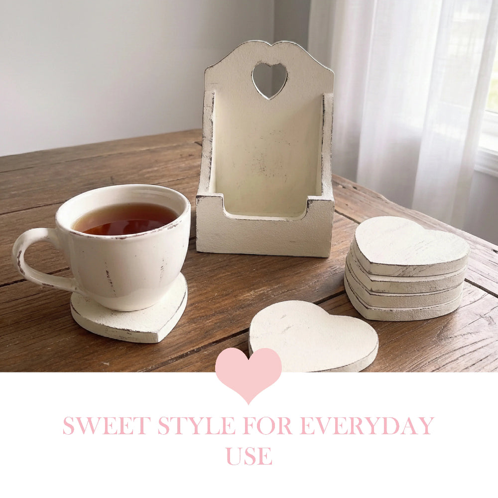 White tea cup on a heart coaster with a matching coaster stack and tall wooden holder on a rustic table with text.