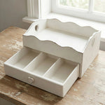 Shabby chic white wooden desk organizer with a heart-shaped drawer pull and scalloped edges on a rustic wooden table.