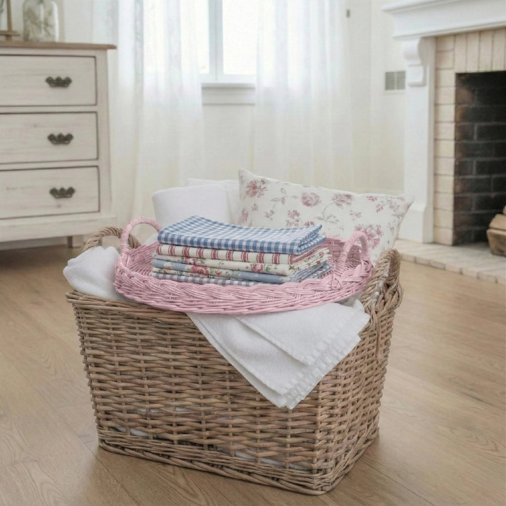Round Woven Tray on a Wicker laundry basket with folded clothes and a wooden floor in a room with a fireplace