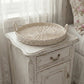 Wicker tray on a distressed wooden side table with floral curtains in the background