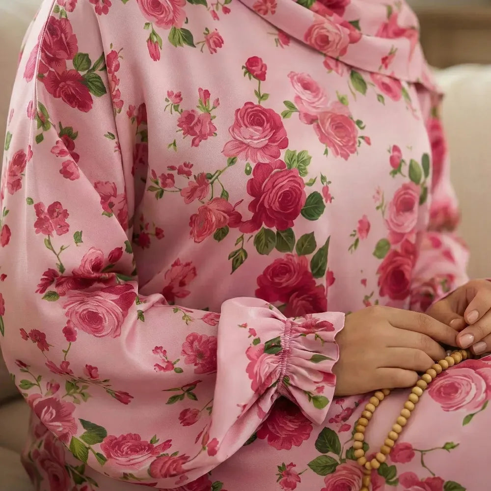 Person wearing a pink floral Isdal Prayer dress holding a rosary.
