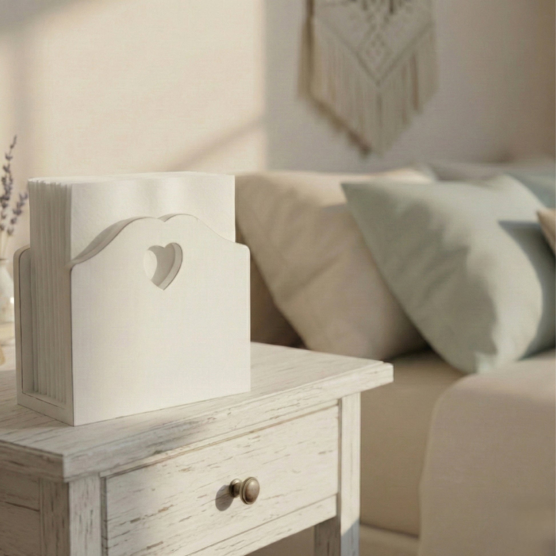 Wooden side table with a heart-shaped cutout next to a beige sofa with cushions.