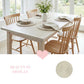 Dining table set with chairs and decorative items in a bright room.